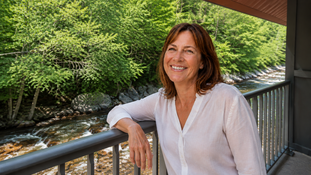 Woman relaxing on a river-facing balcony at Historic Rocky Waters Inn in Gatlinburg