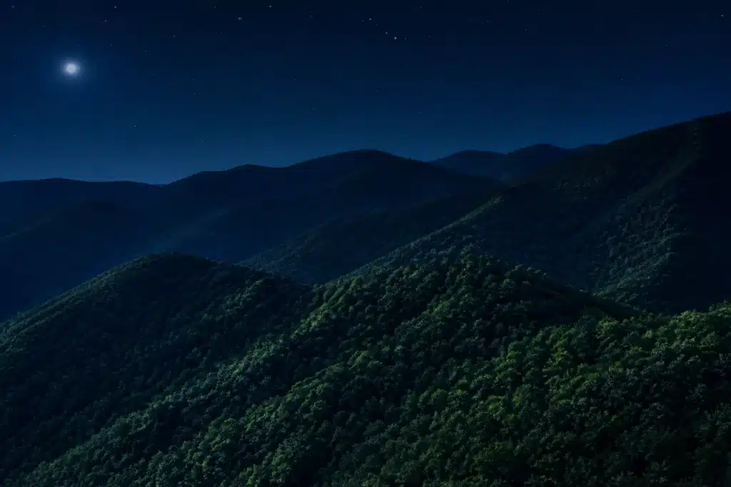 Secluded Cabins in Gatlinburg: Private Mountain Retreats Worth Booking 4 Moon and stars above forested Smoky Mountain ridges at night